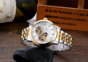 Detailed close-up of an automatic mechanical watch with a skeleton dial on a dark stone