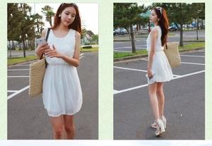 Close-up of white sleeveless dress with floral lace bodice and pleated skirt detail