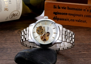 Macro shot of silver automatic watch with hollow gears and diamond markers on stones