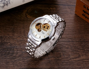 Detail of white skeleton dial with gold gears and silver stainless steel mechanical watch