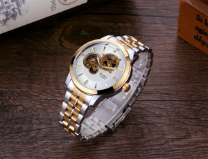 Detail view of the silver and gold automatic mechanical watch with a skeleton dial design