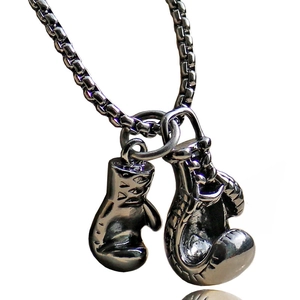 Macro shot of polished gunmetal boxing glove pendants on a sleek box chain necklace