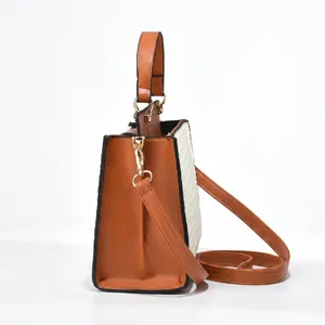 Detail view of woven fabric and brown leather straps on an elegant tote bag
