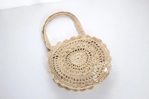 Detailed macro view of the intricate hand-woven hollow flower pattern on the straw tote bag