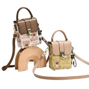 Detail view of mini crossbody bags with cartoon bear prints and metal flip locks