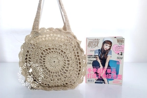 Detail of hand-crocheted hollow floral pattern on a beige bohemian straw beach bag