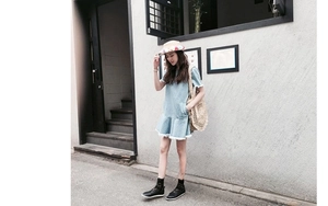 Detail of light blue denim mini dress featuring white fringe hem and practical side pockets
