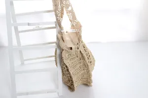Detail of hand-crocheted paper rope tote bag with floral cutout design and secure zipper