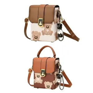 Detail of trendy crossbody bag featuring leather patchwork with cartoon bear pattern