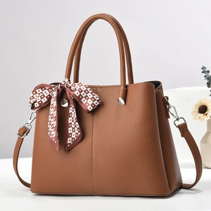 Detail of brown lychee texture tote bag with silk scarf and silver hardware