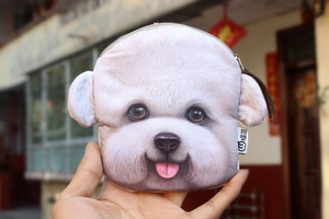 Close-up of a white plush bull terrier coin purse with zipper held by a hand outdoors