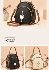Detail of multi-functional mini backpack with golden cat pendant and lychee texture