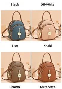 Detail view of mini multi-layer backpack with cute golden cat pendant in four colors