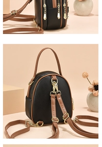 Detail of multi-compartment mini backpack with black lychee leather and gold hardware