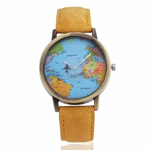 Macro detail of quartz watch with world map dial and airplane second hand on denim strap