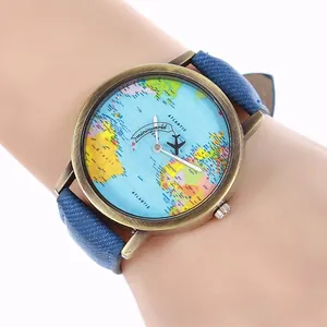 Macro view of vintage world map watch dial with airplane hands and denim fabric strap