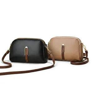 Close-up of minimalist crossbody bag featuring lychee texture leather and gold hardware