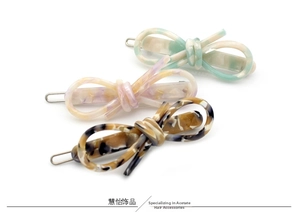 Trois barrettes à cheveux en acétate en forme de nœud aux motifs menthe, rose et écaille