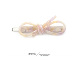Détail d'une barrette en acétate marbré lavande avec nœud minimaliste et clip métal