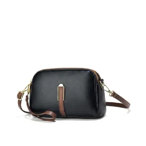 Close-up of double zipper closure and gold H buckle on leather crossbody shell bag