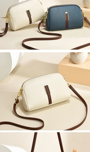 Detail view of lychee pattern leather crossbody bag with dual zipper and gold hardware