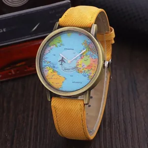 Detail of world map watch dial with airplane pointer and yellow canvas strap