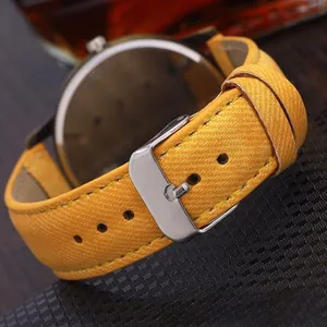 Detail of yellow fabric watch strap with silver stainless steel buckle and neat stitching
