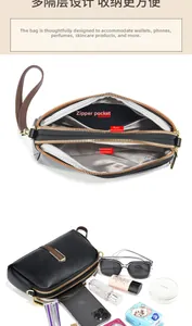 Detail view of the black textured leather bag with three organized zipper compartments