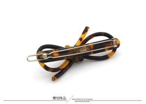 Détail de la pince à cheveux nœud en acétate avec motif écaille de tortue et métal