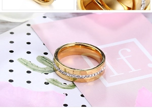 Detailed close-up of a gold titanium ring featuring a single row of white zircon inlay
