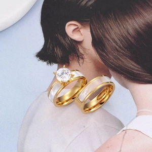 Elegant gold titanium couple rings set with shell inlay and a large cubic zirconia stone