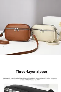 Detail view of small crossbody bag featuring three-layer zipper and lychee grain texture