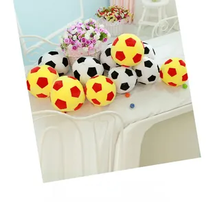 Detail of plush football pillows showing classic black white and red yellow stitched panels
