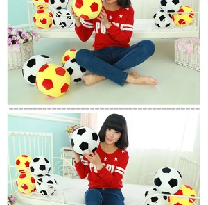 Detail of plush soccer ball pillows in black-white and yellow-red soft plush fabric