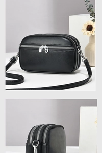 Detail view of the black litchi leather texture and triple-layer silver zipper design