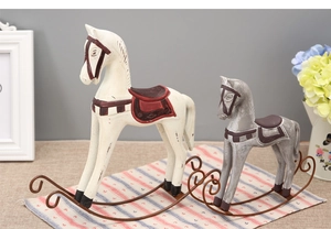Close-up of vintage Nordic wooden rocking horse figurines with rustic distressed finish