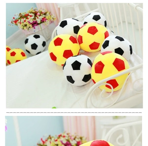 Detailed close-up of soft plush soccer balls in classic black, white and red colors