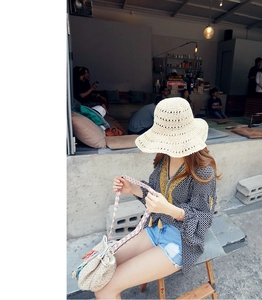 Detail of hand-woven beige straw hat featuring breathable hollow-out floral crochet patterns
