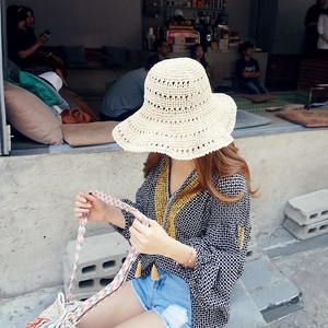 Detail of hand-woven beige straw hat with a wide wavy brim for summer vacation style