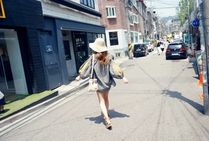 Street view detail of handwoven straw hat with checkered top and mini crossbody bag