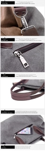 Detail of dark grey canvas tote with brown leather trim, metal hooks and back zip pocket