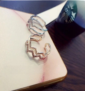 Close-up of double-layered zigzag rings with crystals in silver and rose gold finishes