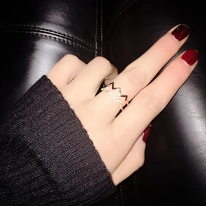 Close-up of a double-layer zigzag ring with gold finish and sparkling crystals on hand