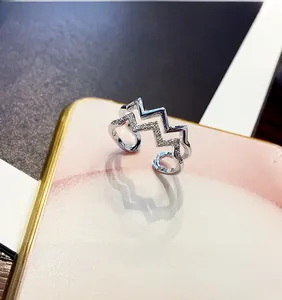 Close-up of double-layer silver wavy ring with micro-paved crystals on marble base