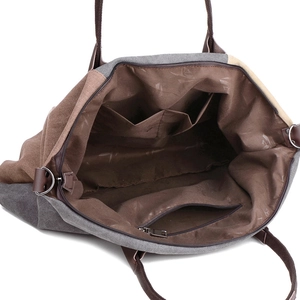 Spacious canvas handbag showing inner pockets with brown lining and secure zipper closure