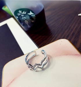 Detail of silver double-layered ring with wave zircon inlay on marble display block