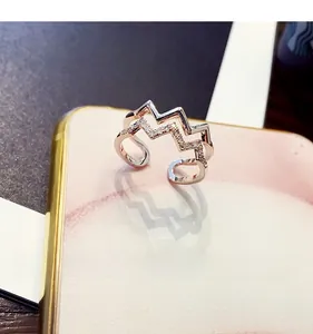 Detail of rose gold double-layer wave ring with shimmering pavé zircon stones
