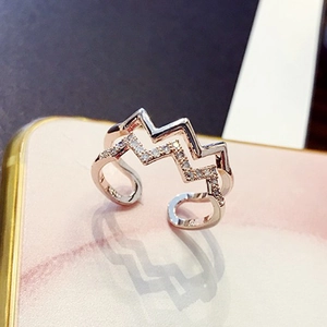 Macro shot of rose gold double-layer wave ring with shimmering micro-pave zircon crystals