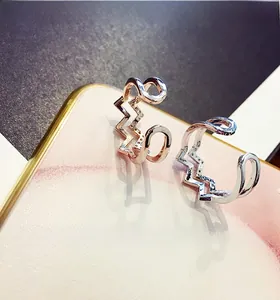 Detail of rose gold and silver wave rings with pavé cubic zirconia on marble board