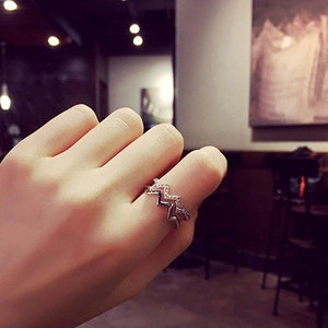 Detail of silver wavy double-layer ring with sparkling zircon inlay on model hand